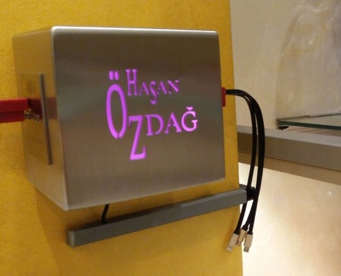 Hier sehen Sie eine Edelstahl-Ladestation/Cube der Orientalischen Feinkonditorei Hasan Özdag GmbH in Köln mit vier USB-Ladebuchsen und LED-RGB beleuchteten Logo
